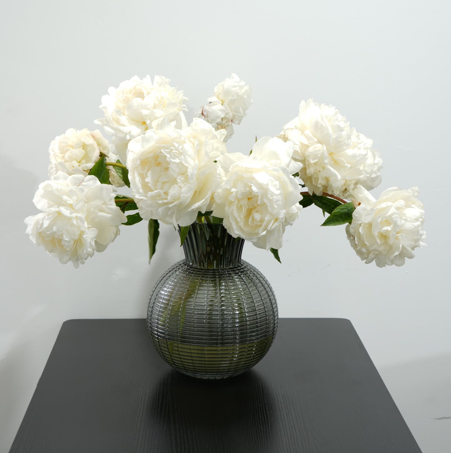 زهور الفاوانيا البيضاء الأنيقة في مزهرية زجاجية مصممة